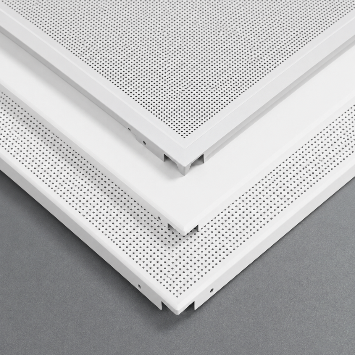 Close-up of white ceiling panels with perforated design on a gray background