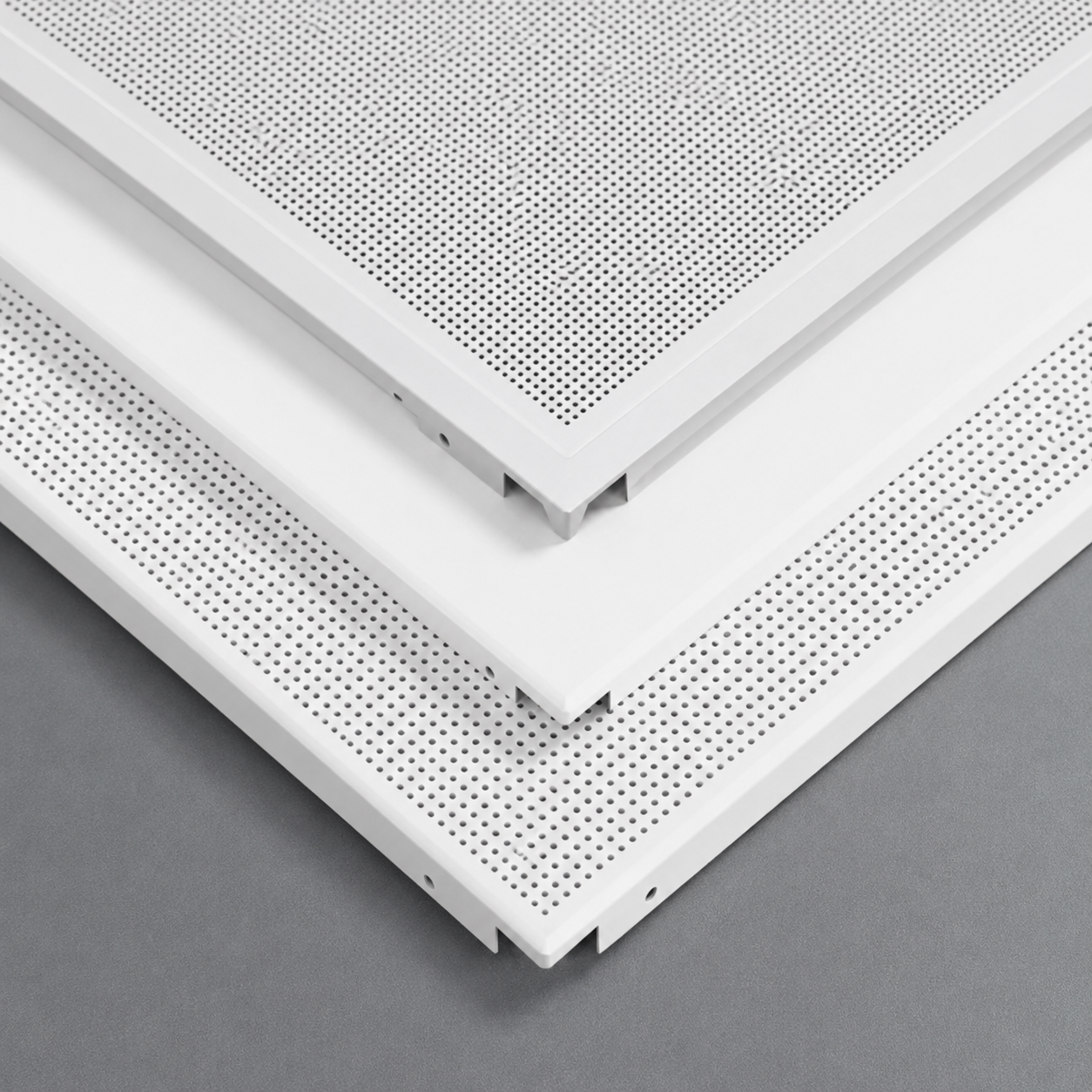 Close-up of white ceiling panels with perforated design on a gray background