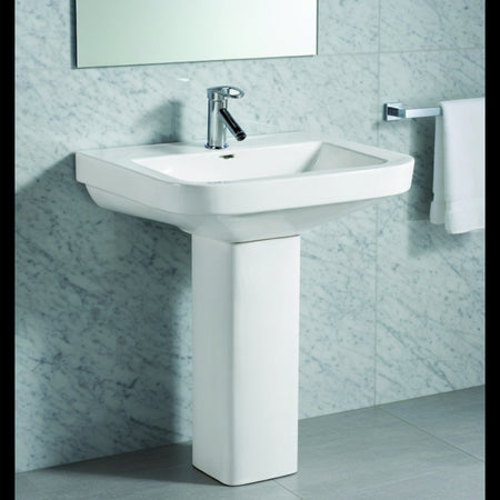Bathroom sink with a mirror and towel on a tiled wall.