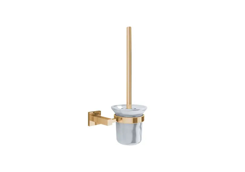 A wall-mounted toilet brush set with a brushed gold metal bracket and handle, a clear glass bowl, and a gold accent band.